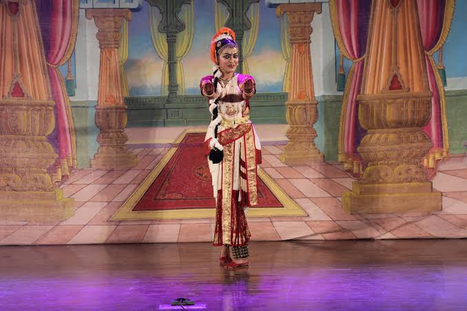 Solo dancer center stage with palace backdrop